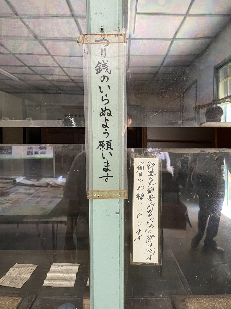 駅の窓口。「つり銭のいらぬよう願います」と手書きで書いてある。